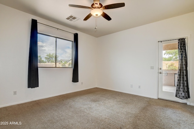 carpeted empty room featuring baseboards, ceiling fan, and visible vents