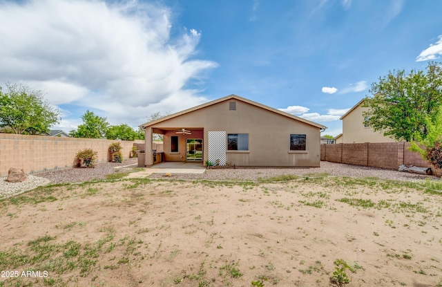 back of property with a fenced backyard, ceiling fan, a patio area, and stucco siding