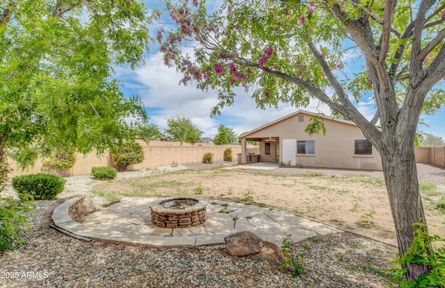 view of yard featuring a fenced backyard, a fire pit, and a patio area