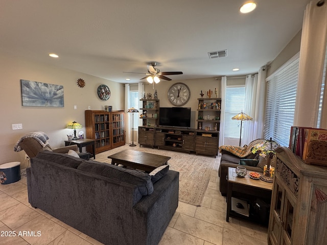 tiled living room featuring ceiling fan and plenty of natural light