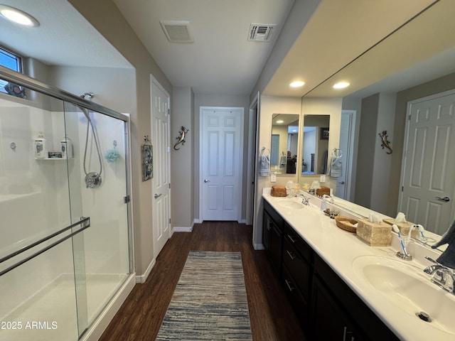 bathroom featuring vanity, a shower with shower door, and hardwood / wood-style floors