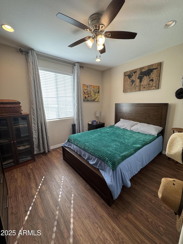 bedroom featuring a textured ceiling, ceiling fan, and dark hardwood / wood-style floors