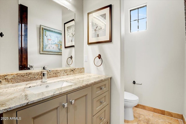 bathroom with tile patterned floors, vanity, toilet, and baseboards