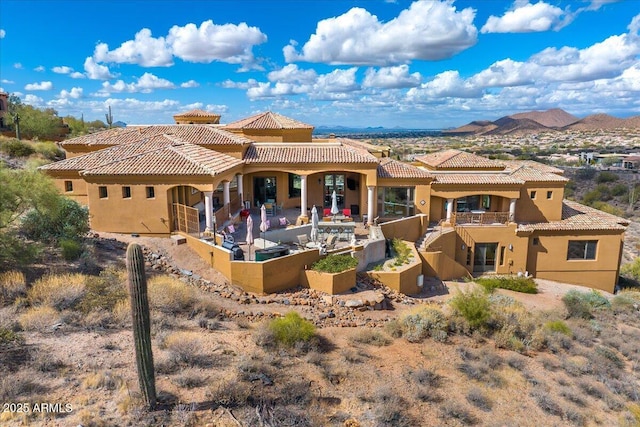 rear view of property with a patio area, a mountain view, and stucco siding