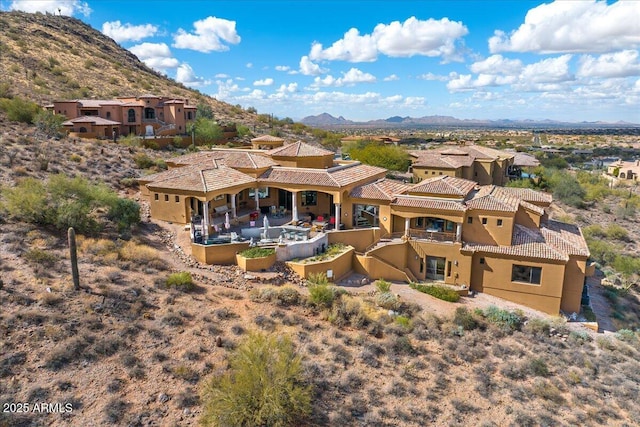 exterior space featuring a tile roof, a mountain view, and stucco siding