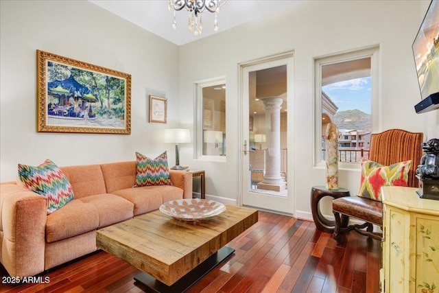 living room with a notable chandelier, baseboards, and dark wood-type flooring