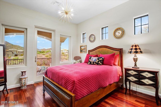 bedroom with baseboards, visible vents, hardwood / wood-style floors, access to exterior, and a notable chandelier