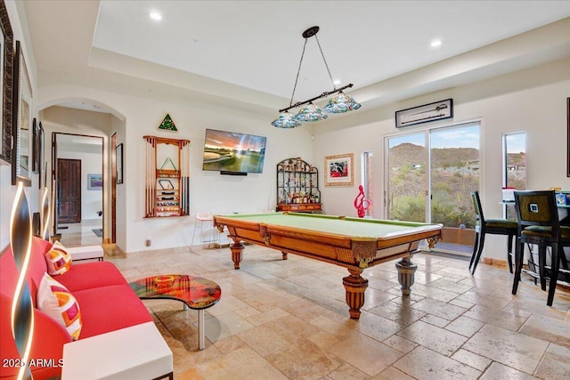 recreation room with arched walkways, recessed lighting, pool table, a tray ceiling, and stone tile flooring