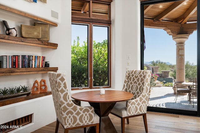 dining room featuring a wealth of natural light, wooden ceiling, and light hardwood / wood-style floors