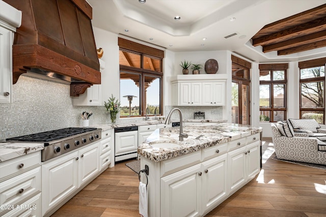 kitchen featuring decorative backsplash, light hardwood / wood-style floors, white cabinetry, and stainless steel gas cooktop