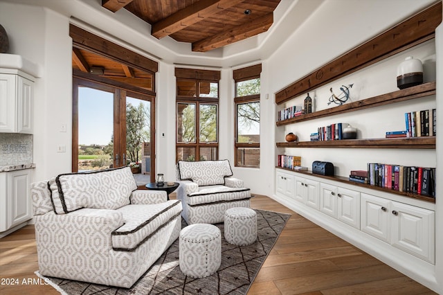 living area with beamed ceiling, wood-type flooring, a wealth of natural light, and wooden ceiling