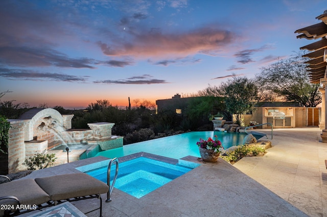 pool at dusk with a grill, pool water feature, area for grilling, an in ground hot tub, and a patio