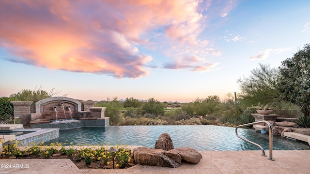 pool at dusk with pool water feature