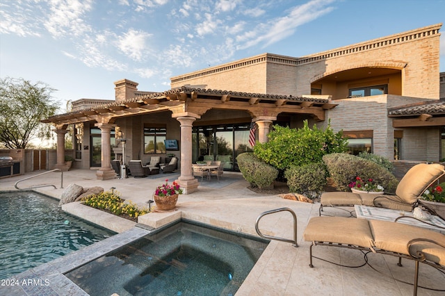 back of house featuring a pool with hot tub, a patio area, and an outdoor hangout area