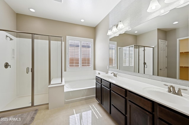 bathroom featuring tile patterned floors, a stall shower, a garden tub, and a sink