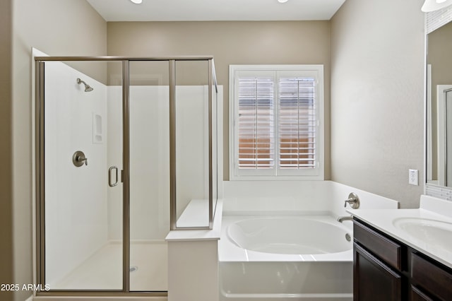 full bath with a stall shower, vanity, and a garden tub