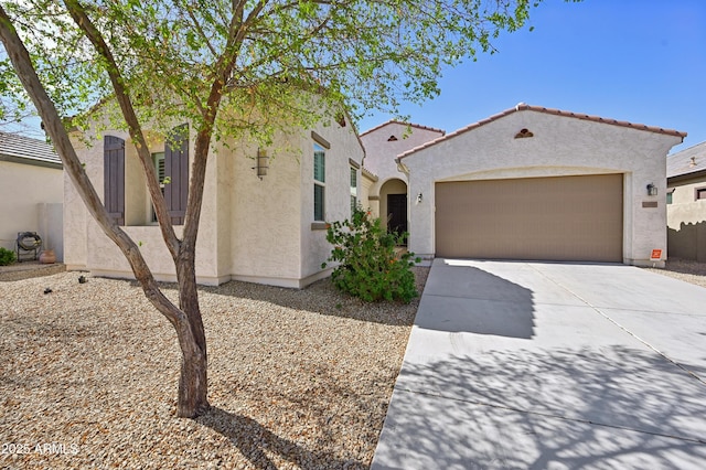 mediterranean / spanish house with a tile roof, stucco siding, and concrete driveway