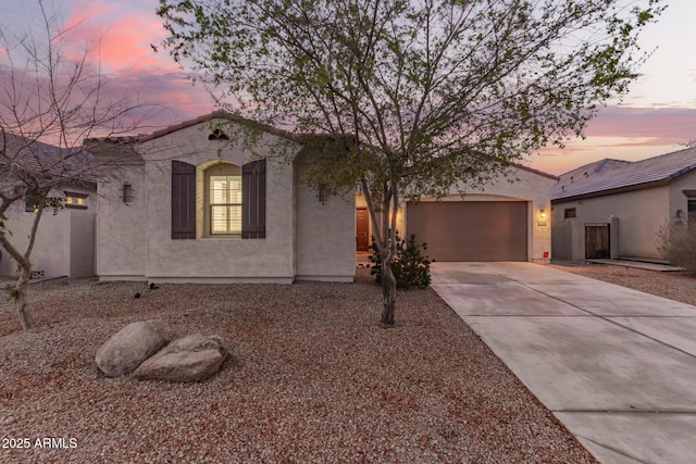 view of front of property with stucco siding, driveway, and a garage