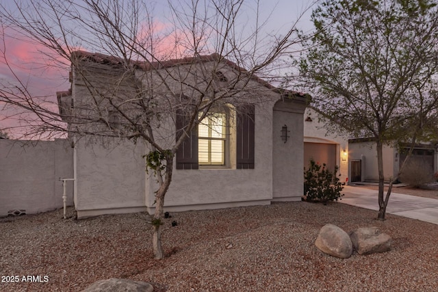 property exterior at dusk with stucco siding