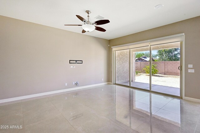 empty room featuring a ceiling fan and baseboards