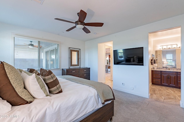 13719 W Amberwing St, Peoria, AZ 85383 - bedroom with light carpet, baseboards, connected bathroom, and a ceiling fan
