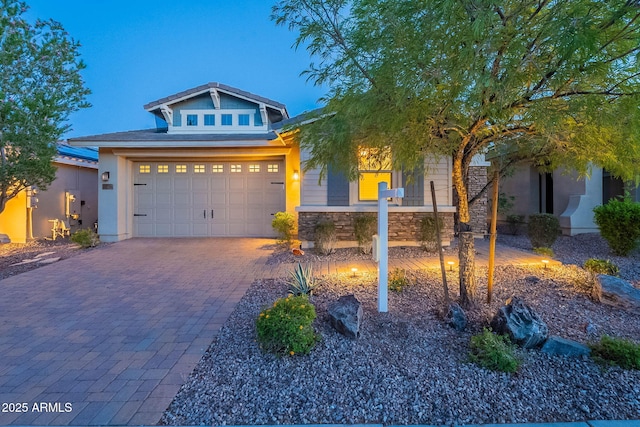 13719 W Amberwing St, Peoria, AZ 85383 - craftsman house with decorative driveway, stone siding, stucco siding, and an attached garage