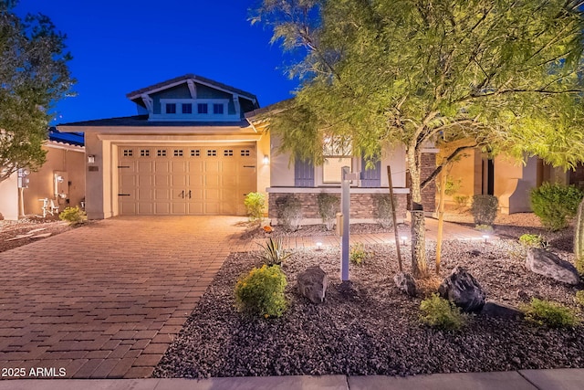 13719 W Amberwing St, Peoria, AZ 85383 - view of front of home featuring stucco siding, an attached garage, decorative driveway, and stone siding