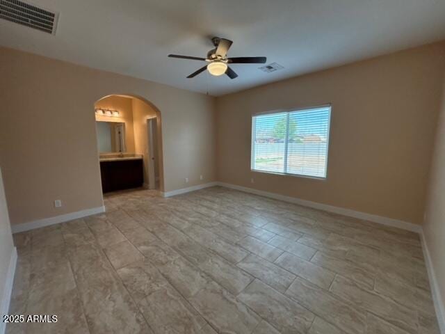 unfurnished bedroom with connected bathroom and ceiling fan