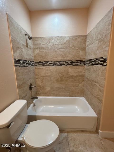 bathroom featuring tiled shower / bath and toilet