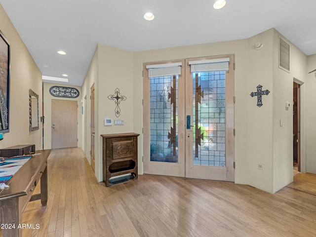 foyer with french doors and light hardwood / wood-style floors