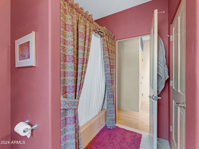 bathroom with wood-type flooring and shower / tub combo