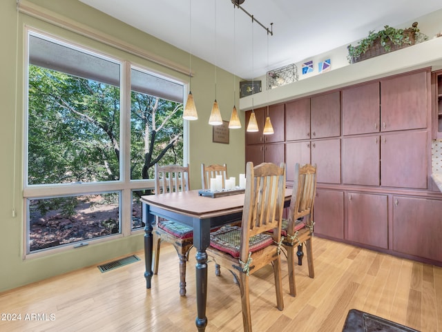 dining room with light wood-type flooring and rail lighting