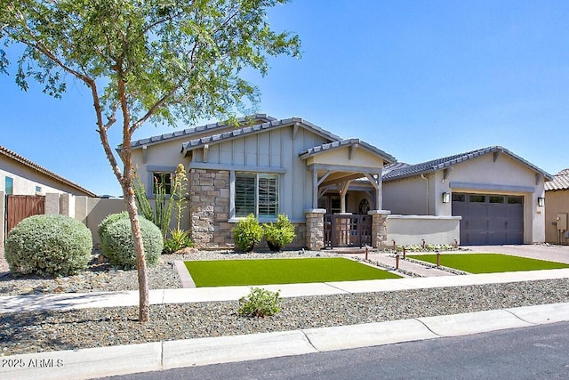 3118 E Gary Way, Phoenix, AZ 85042 - craftsman-style house featuring a garage, driveway, a tile roof, and stone siding