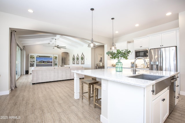 3118 E Gary Way, Phoenix, AZ 85042 - kitchen with arched walkways, a sink, ceiling fan, appliances with stainless steel finishes, and a kitchen island with sink