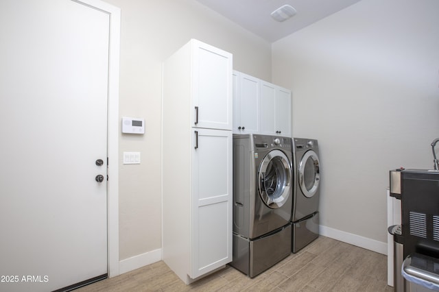 3118 E Gary Way, Phoenix, AZ 85042 - laundry area featuring washing machine and dryer, light wood-style floors, cabinet space, and baseboards