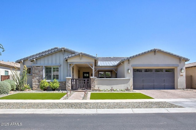 3118 E Gary Way, Phoenix, AZ 85042 - view of front of house featuring a garage, driveway, a front yard, and stucco siding