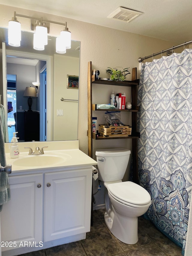 bathroom with visible vents, a textured wall, toilet, tile patterned floors, and vanity