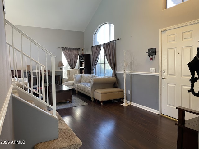 living area featuring stairs, high vaulted ceiling, and wood finished floors