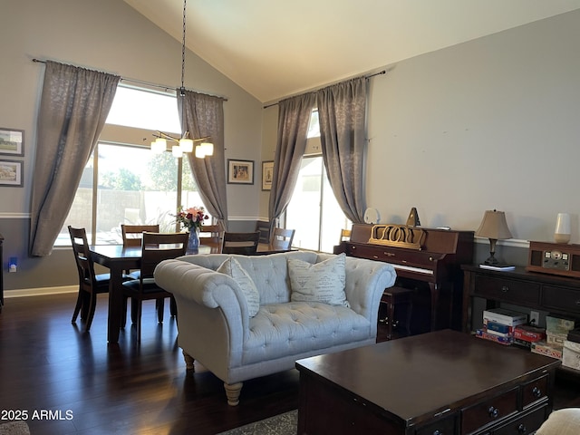 living area with high vaulted ceiling, dark wood finished floors, and a notable chandelier