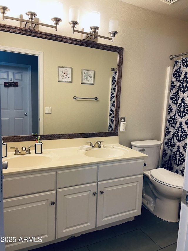 full bathroom with tile patterned flooring, a sink, toilet, and double vanity