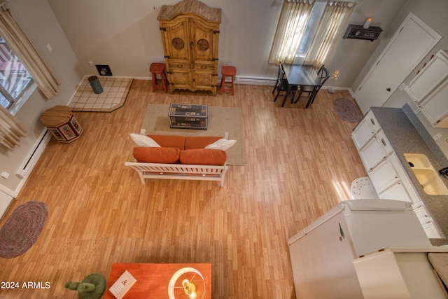 living room featuring a baseboard heating unit and light wood-type flooring