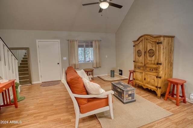 living room with high vaulted ceiling, ceiling fan, and light wood-type flooring