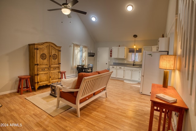 living room with a wealth of natural light, light hardwood / wood-style floors, ceiling fan, and high vaulted ceiling