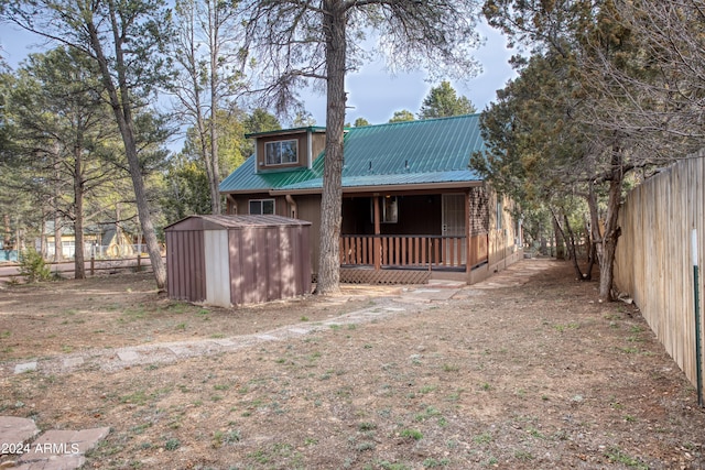 back of house featuring a storage shed