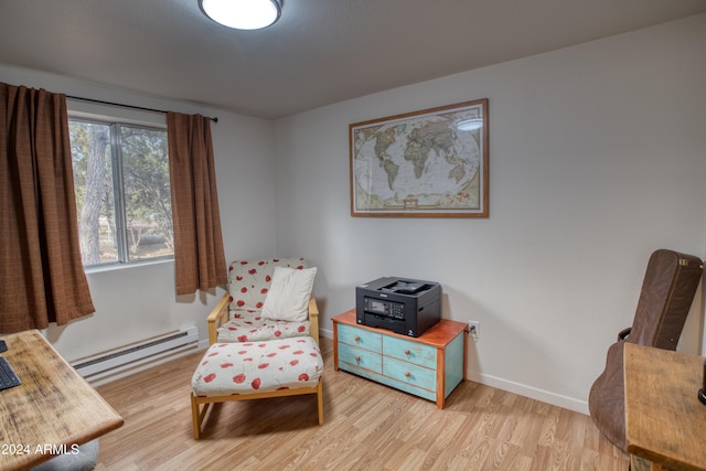 sitting room with light hardwood / wood-style floors and a baseboard heating unit