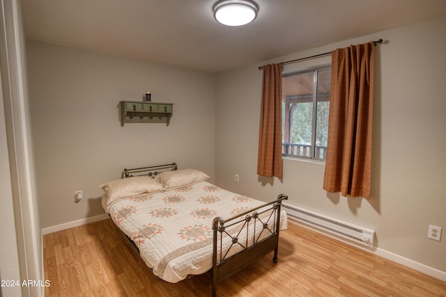 bedroom featuring a baseboard radiator and light wood-type flooring