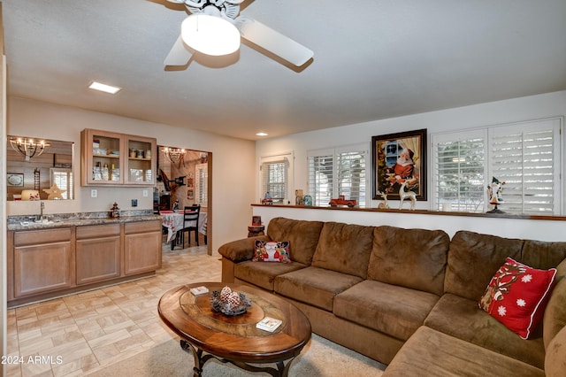 living room with sink and ceiling fan with notable chandelier