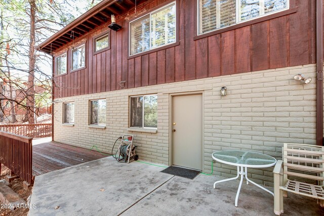 rear view of house featuring a wooden deck and a patio