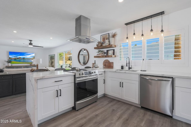 kitchen featuring sink, white cabinetry, stainless steel appliances, island range hood, and kitchen peninsula