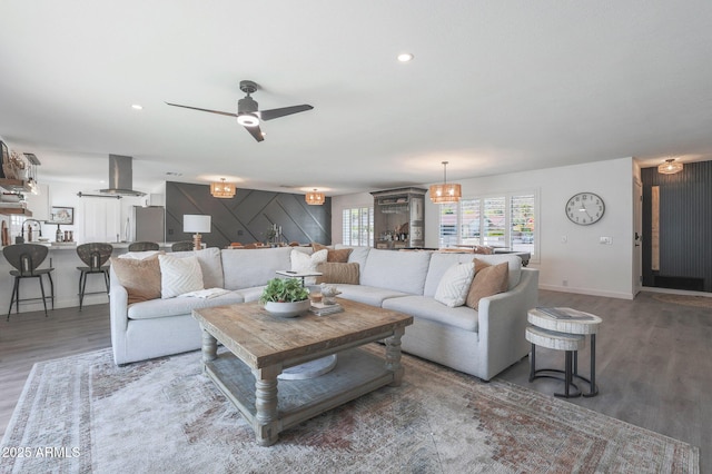 living room featuring dark wood-type flooring, ceiling fan, and sink